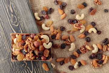 Mix of nuts and raisins on a wooden table.
