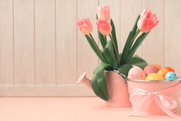 Easter eggs, ceramic hen and wase with tulips on pink wooden table. Easter celebration concept. Soft focus