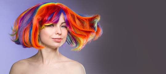 Woman hair as color splash. Rainbow up do short haircut. Beautiful young girl model with glowing  healthy skin. Smiling, positive and happy woman