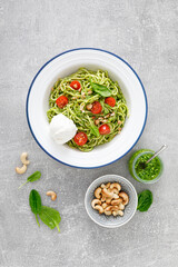 Pasta with spinach pesto, cashew nuts and soft cream cheese. Top view