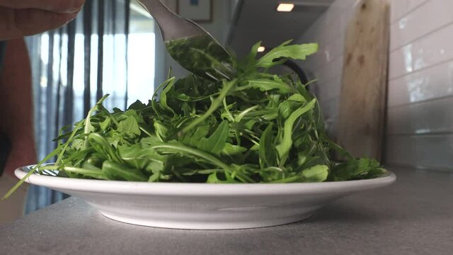 A pile of ruccola salad in a modern kitchen