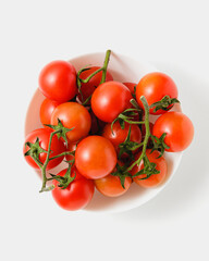 Cherry tomatoes in bowl on white background.
