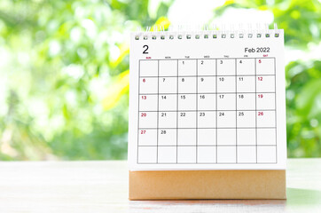 February 2022 Calendar desk for organizer to plan and reminder on wooden table on nature background.
