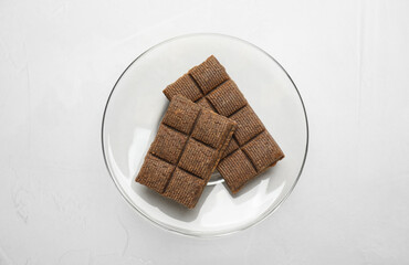 Glass plate with delicious and healthy hematogen on white table, top view