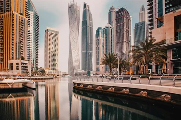 Foto op Plexiglas DUBAI, UAE - FEBRUARY 2018: View of modern skyscrapers shining in sunrise lights  in Dubai Marina in Dubai, UAE. © Melinda Nagy
