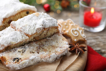 Traditional Christmas Stollen with icing sugar on wooden table, closeup