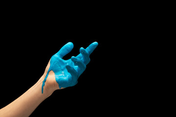 Male hand painted blue gesturing isolated on dark studio background. Concept of human relation,...