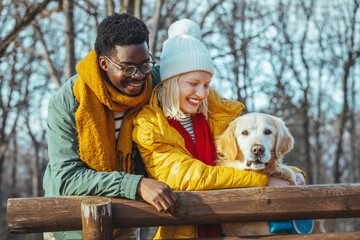 Photo of a young couple and their dog camping in the woods on a beautiful autumn day; spending time...