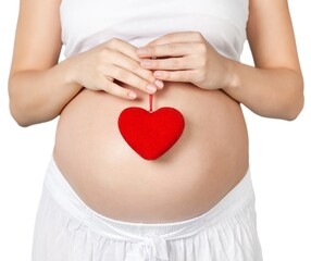 Pregnant mother showing her belly and holding a mini heart