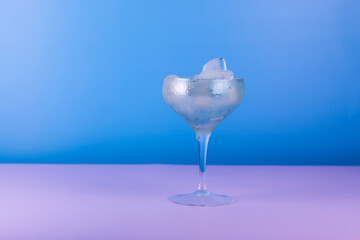 Cocktail glasses with colorful drink on blue and pink background. Summer cocktail party background.