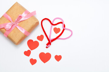 Eco gift boxes with pink ribbon and red felt hearts on white background