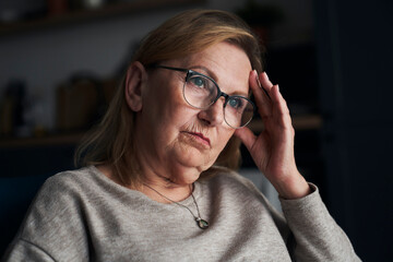 Thoughtful caucasian senior woman sitting and looking away