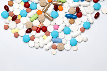 Assorted colorful pills and capsules on white background close up, horizontal, copy space, selective focus, medical concept.