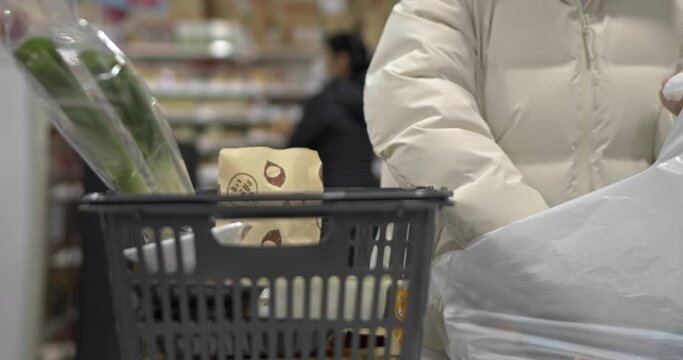スーパーで買い物後に袋詰をする女性