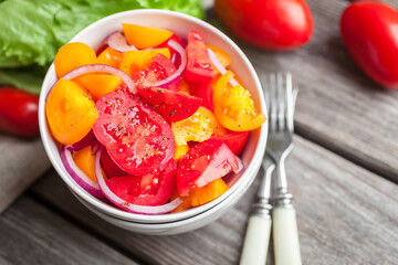 Salad with fresh vegetables, colorful tomatoes, onions and spices. Healthy food 