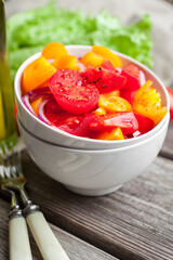 Salad with fresh vegetables, colorful tomatoes, onions and spices. Healthy food 