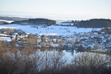 Schalkenmehrener Maar mit Dorf im Winter