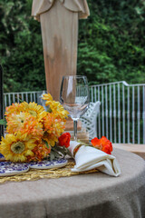 Una mesa con flores amarillas y finas copas en un bosque 