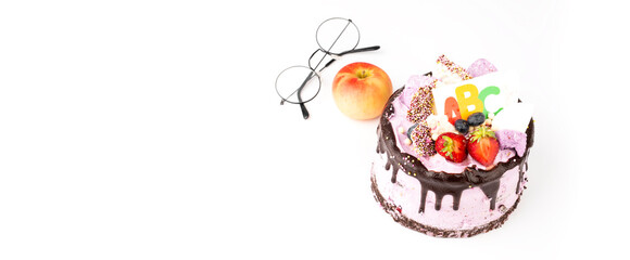 Beginning of the school year concept, festive cake with ABC, apple and glasses.