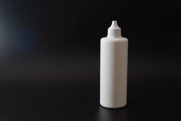 White plastic bottle on black background