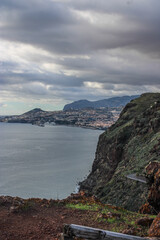 Grandes monta&ntilde;as de rocas en las costas del mar con un cielo azul y nubes blancas 