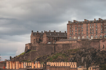 Stunning aerial view of Edinburgh in Scotland, with the castle dominates the skyline, casting its shadow over the surrounding historic town occupying commanding position on volcanic crag with cliffs