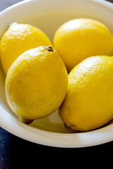 fresh lemons in white bowl close up