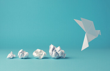 Crumpled paper balls with an origami paper dove, peace, freedom or opportunities - obrazy, fototapety, plakaty