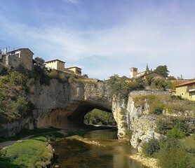 Obraz premium Puentedey pueblo medieval del siglo XV en las merindades de Burgos pueblo sobre cueva con rio en día de cielo azul