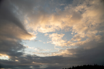 Fototapeta na wymiar Orange clouds at sunset with overcast sky