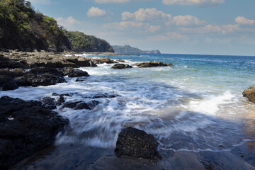 Obraz premium The waves are breaking on the rocky Pacific coast. Costa Rica