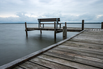 Naklejka premium Wooden jetty with benches by the sea