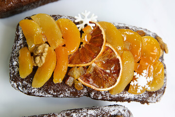 Traditional  Christmas stollen on white background. Dessert is decorated with dried fruits and candied fruits.