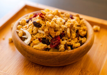 wooden bowl with granola on the black table. close up breakfast