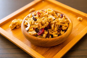 wooden bowl with granola on the black table. close up breakfast