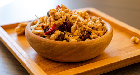 wooden bowl with granola on the black table. close up breakfast
