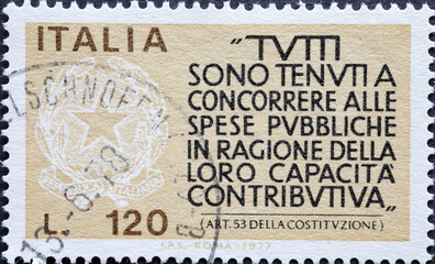 Italy - circa 1977: a postage stamp from Italy showing a text. Encouragement to Taxpayers