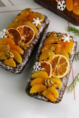 Traditional  Christmas stollen on white background. Dessert is decorated with dried fruits and candied fruits.