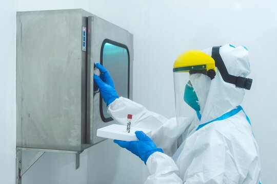 A Medical Technician About To Open A Pass Box To Place A Test Sample At A Cleanroom At A Laboratory.