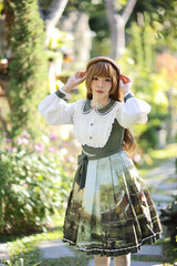 A beautiful woman in lolita dress in garden background Japanese street fashion portrait