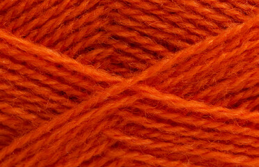 Woolen, fluffy white knitting threads are wound into a ball. Soft, warm background. Close-up.