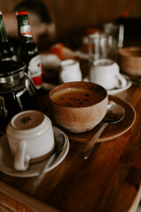 A rustic outdoor dining scene in Ibiza featuring a wooden table set with gourmet snacks, crispy chips, fresh dips, and refreshing drinks under the sun. A perfect Mediterranean culinary experience
