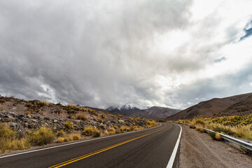 Salta road curve in Argentina with Nevado de Acay hill in the background