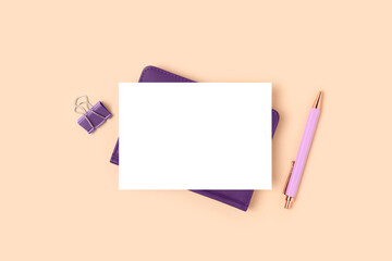 Blank paper card mockup and purple stationery on a beige background. Minimalistic business workspace.