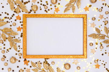 Empty frame made from golden glittering decorations on a blue background.