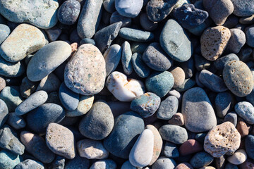 Natural beach rocky textured background in a light of sun.