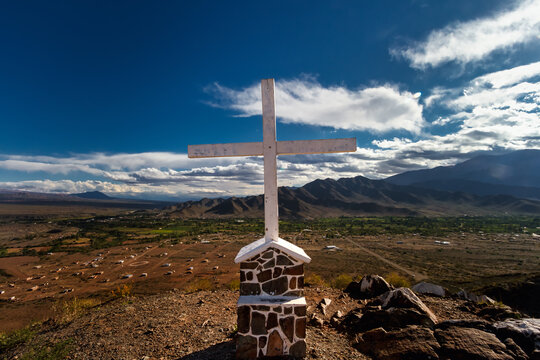 Shrine with a cross, with mountains and the town of Cachi in the background in Salta, Argentina