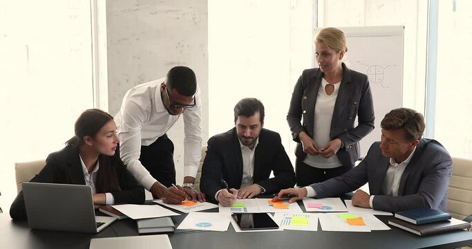 Diverse employee work on project financial statement profit result, do paperwork, discuss marketing strategy at office meeting, share ideas, brainstorm together take part at corporate planning concept