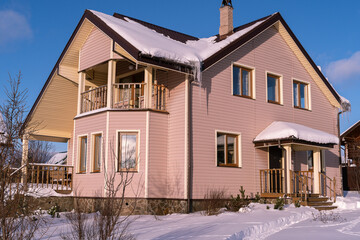 Country house with tiled roof and chimney in countryside. Architecture at the countryside. Winter landscape