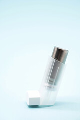 Asthma inhaler on blue background, copy space. Aerosol for inhalation, treatment of bronchial asthma, COPD. Pharmaceutical product for treat lung inflammation and prevent asthma attack. 